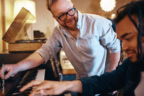 Smiling producer working with a keyboard player in his studio photo