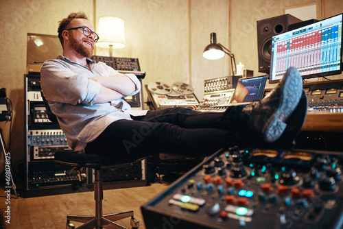 Smiling music producer relaxing in his recording studio