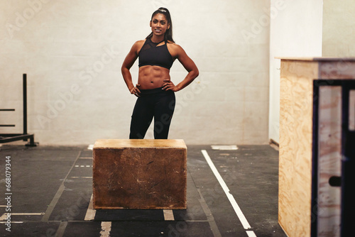 Smiling woman ready for a gym box jump class photo