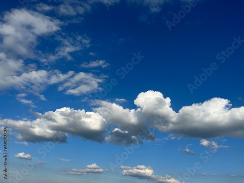 White cumulus clouds on the background of blue sky, background