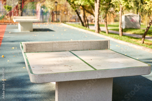 Table tennis tables in autumn public park. Concrete tennis table in a city park ping pong game photo