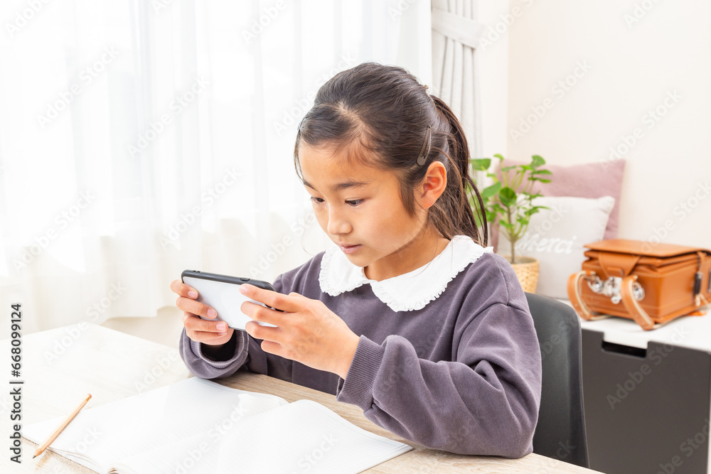 スマートフォンを使って勉強する女の子