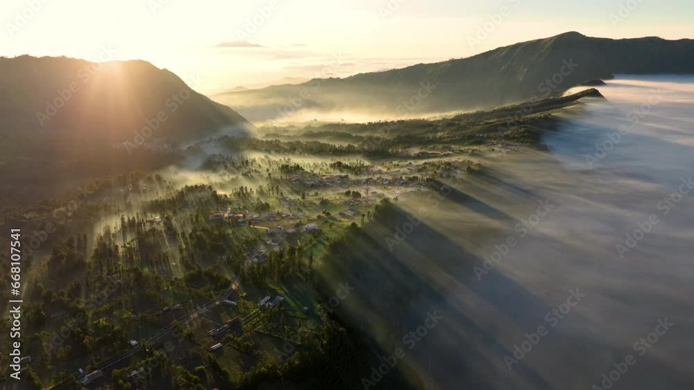 Aerial view of beautiful view village in the morning, sea of mist near Mount Bromo. Located in Bromo, Tengger, Semeru National Park, East Java, Indonesia. Aerial view of beautiful view village in the morning, sea of mist near Mount Bromo. Located in Bromo, Tengger, Semeru National Park, East Java, Indonesia.