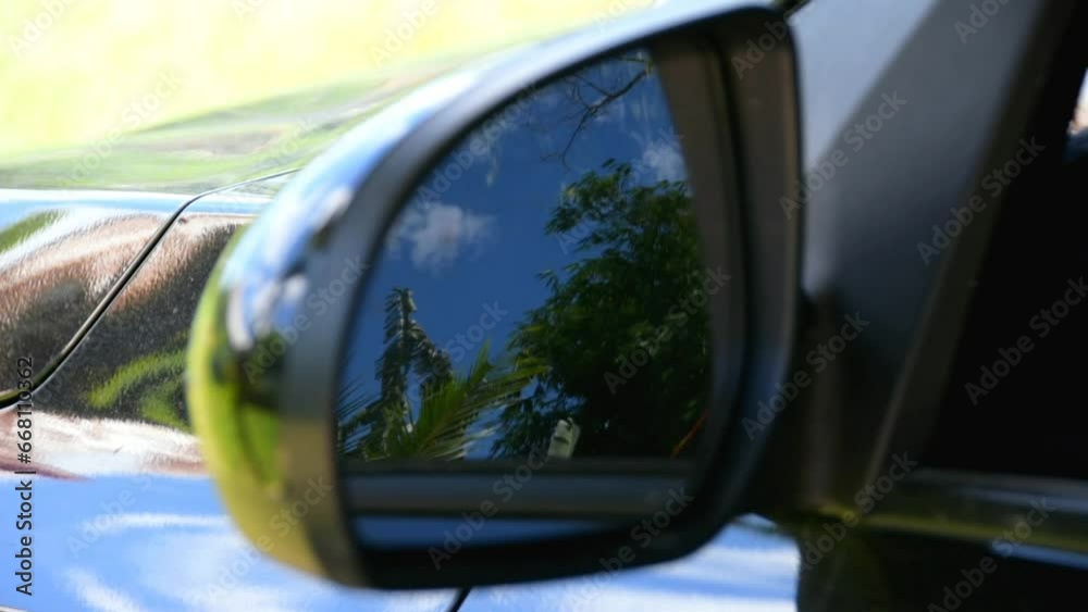 Reflection of a tropical landscape in the rear view mirror of a car Reflection of a tropical landscape in the rear view mirror of a car