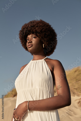 Black woman in white dress standing in countryside