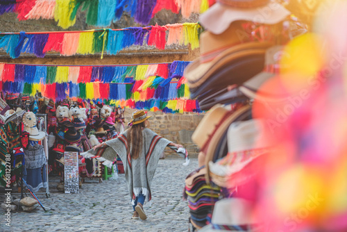 Traveler hipster girl in hat with backpack exploring market of Ollantaytambo Ruins in Sacred Valley of Peru. travel Concept photo