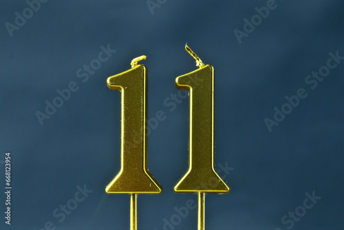 close up on the gold number eleven candle on a dark background.
 photo