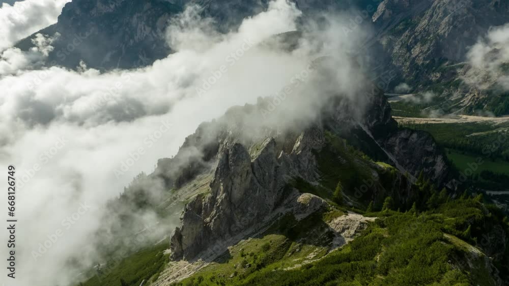 An evocative timelapse captured by a drone orbiting around rugged cliffs, showcasing clouds majestically ascending in the pristine Dolomites of South Tyrol. An evocative timelapse captured by a drone orbiting around rugged cliffs, showcasing clouds majestically ascending in the pristine Dolomites of South Tyrol.