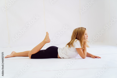 Cheerful teenage girl in white t-shirt and black breeches on white background photo