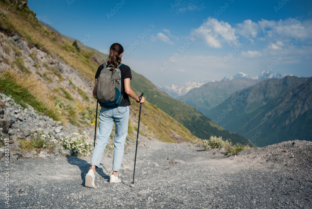 Girl walks in the mountains in summer. Trekking in the mountains