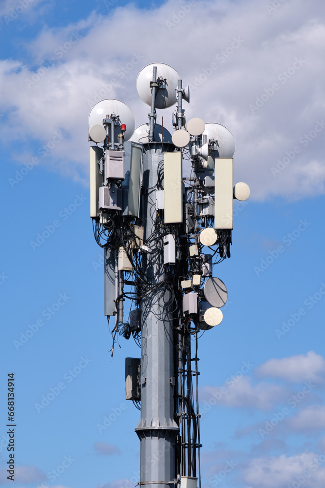 Telecommunication Pole With Satellite Dishes And Antennas, Blue Sky And Clouds Background