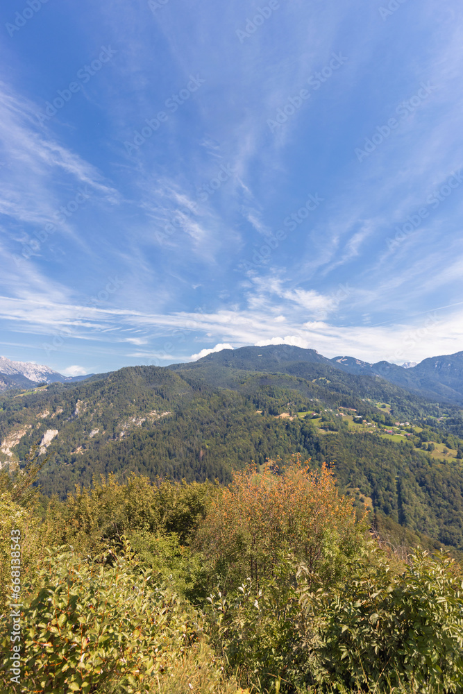 Mountain landscape with green forests and blue summer sky