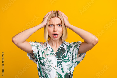 Photo portrait of pretty young girl touch head terrified face dressed stylish leaves print outfit isolated on yellow color background