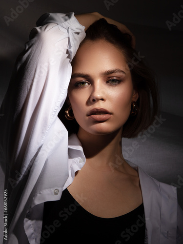 A lovely model with gold rings, earrings, and a bracelet. Jewelry shop. Fashion, Beauty . Portrait of a beautiful young woman with jewellery. Stylish brunette model with natural beauty and long hair