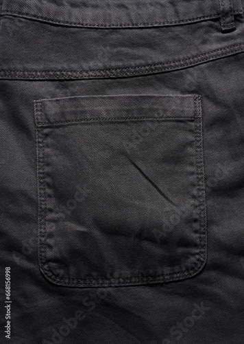 Back pocket of black jeans, close up