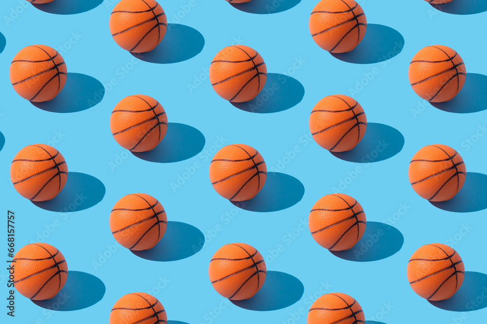 Trendy basketball pattern composition on light blue background. Minimal sport concept. Creative orange ball arrangement. Basketball aesthetic background..