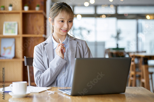 カフェでオンラインミーティングをする女性 photo