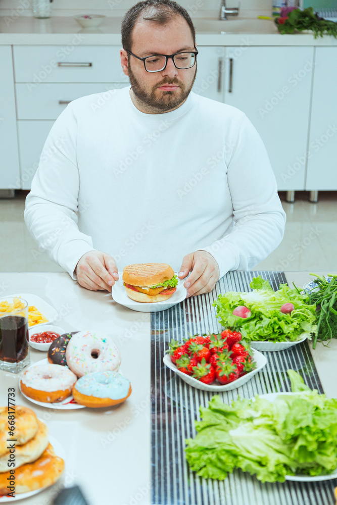 Fat man eating a cheeseburger and fast food meal with a drink. Unhealthy lifestyle, snack with carbohydrate food. Problems with health, bulimia, and heart disease.