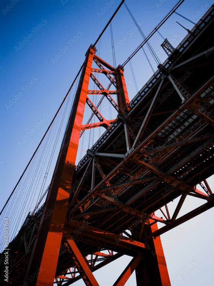 Fototapeta premium Vertical low angle shot of the 25 April bridge in Lisbon, Portugal