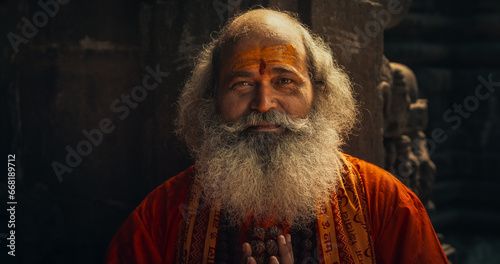 Tableau sur toile Portrait of a Senior Hindu Monk Looking at the Camera and Smiling in an Ancient Temple
