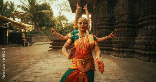 Dramatic Performance Done by Indian Girls Practicing the Art of Bharatanatyam in an Ancient Temple. Expressive Young Females in Colourful Traditional Sari Dancing Folk Dance Choreography