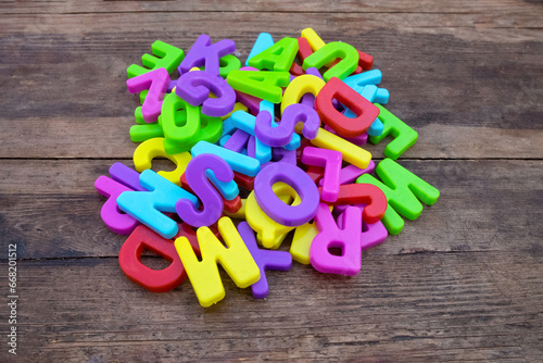 Colored plastic letters of the English alphabet on a wooden surface