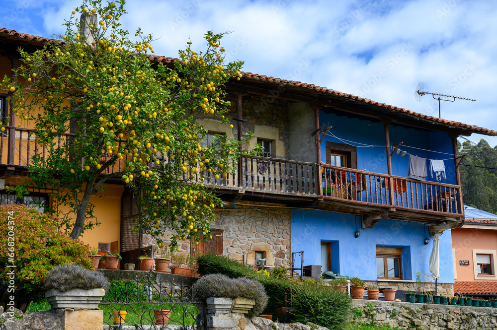 Travelling by car in Asturias, North of Spain. View on village, houses, gardens near Villaviciosa