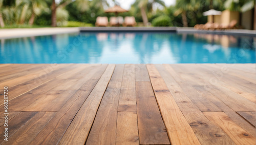 Empty wooden table in front with blurred background of swimming pool