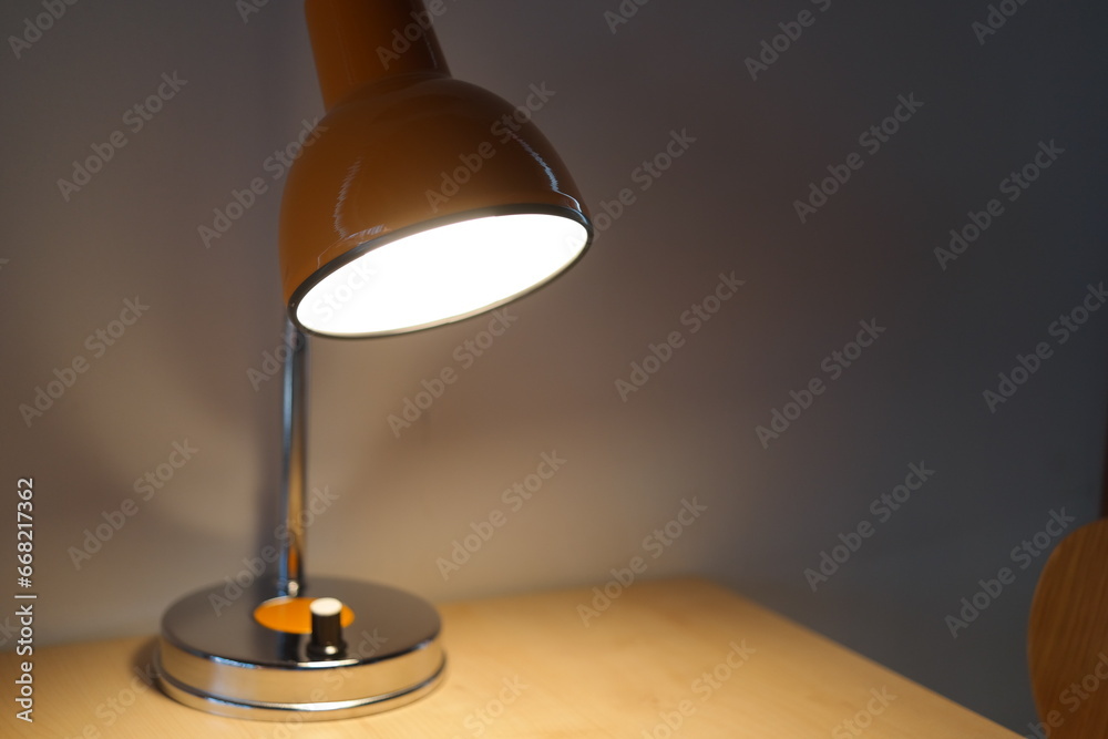 There is a lighted stand on the desk. There is a lighted stand on the desk.