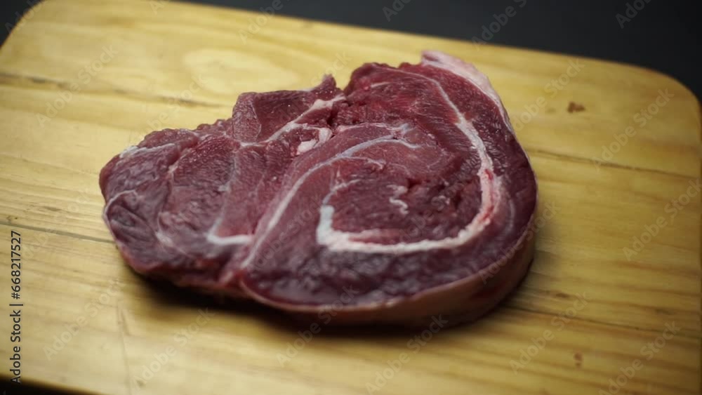 Raw steak in wooden plate on black background. Raw steak in wooden plate on black background.