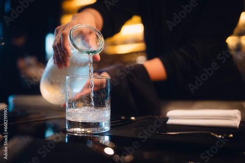 Kellnerin serviert Wasser im Restaurant