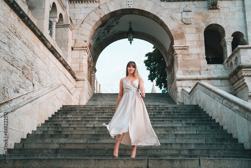 Young Woman walking down the stairs in a dress in Budapest at the Fisherman's Bastion, Halászbástya