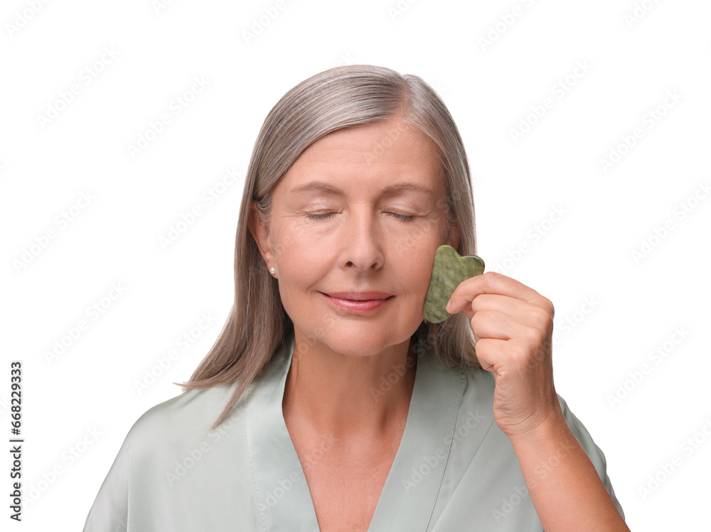 Woman massaging her face with jade gua sha tool isolated on white Woman massaging her face with jade gua sha tool isolated on white