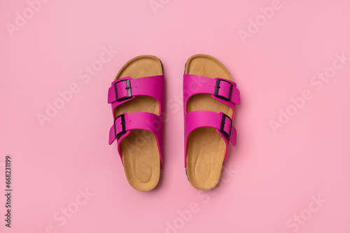 Trendy fashion footwear mockup. Leather pink magenta sandals birkenstocks on pink background top view flat lay. Unisex summer shoes, genuine leather flip flops with cork soles