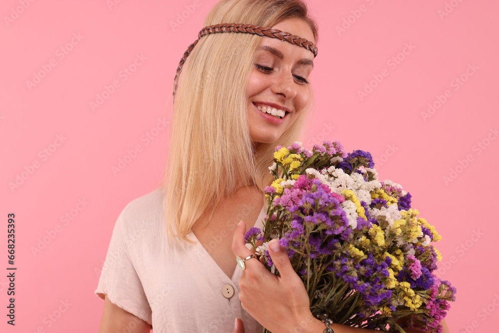 Portrait of smiling hippie woman with bouquet of flowers on pink background Portrait of smiling hippie woman with bouquet of flowers on pink background