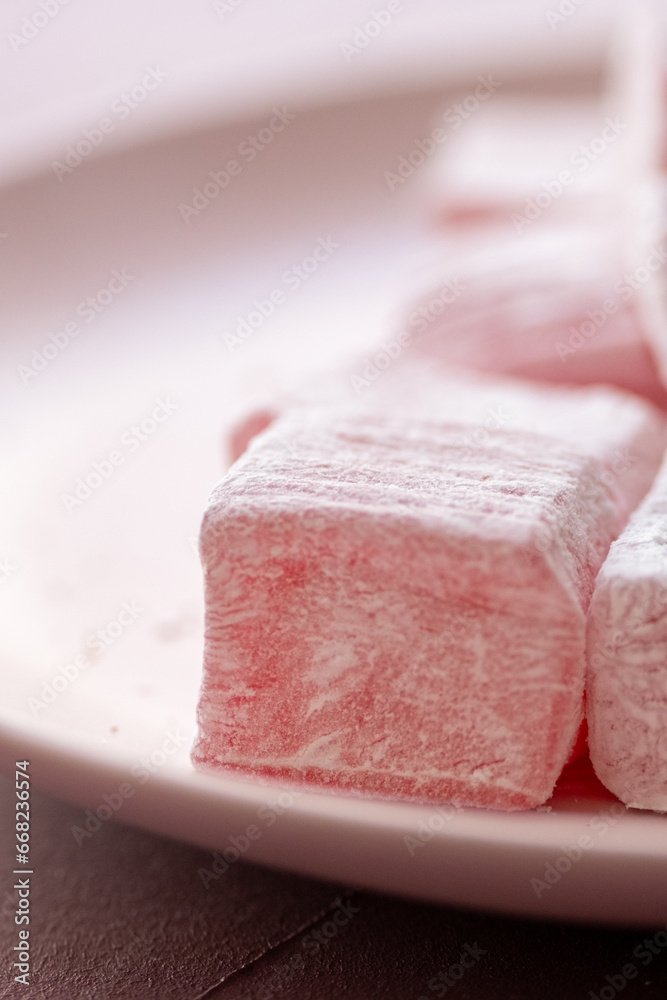 Pink Turkish delights with roses on a pink plate
Pink Turkish delights with roses on a pink plate