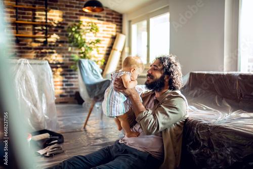 Loving father shares a tender moment with his infant amidst home renovations photo