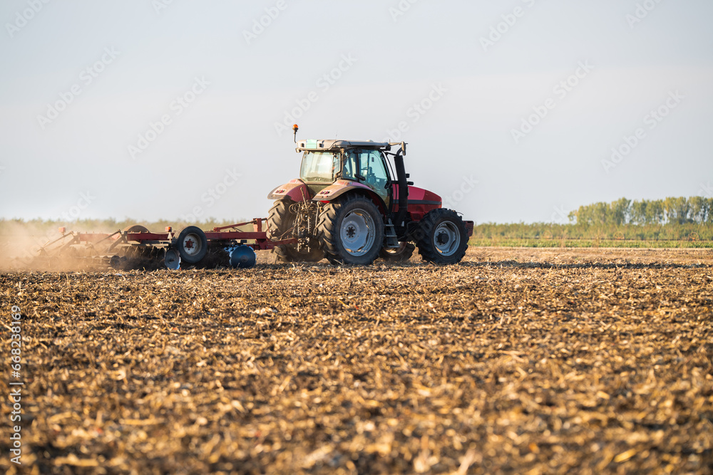 Fototapeta premium Farmer preparing his field in a tractor