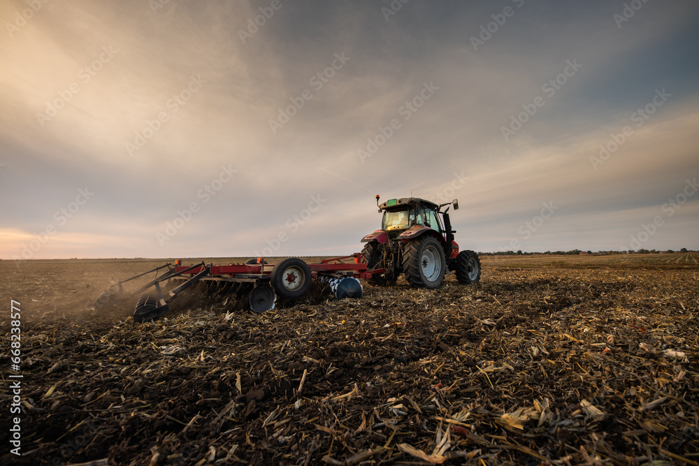 Fototapeta premium Farmer preparing his field in a tractor