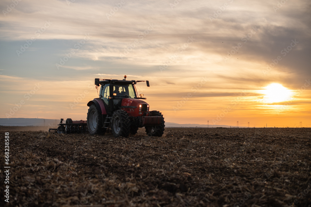 Fototapeta premium Farmer preparing his field in a tractor