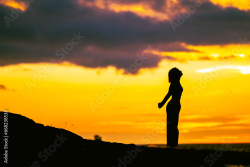 silhouette of a woman doing yoga on sunset