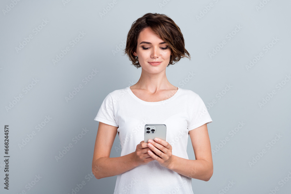 Porrtait of gorgeous positive lady hold use apple iphone gadget chatting texing isolated on grey color background Porrtait of gorgeous positive lady hold use apple iphone gadget chatting texing isolated on grey color background