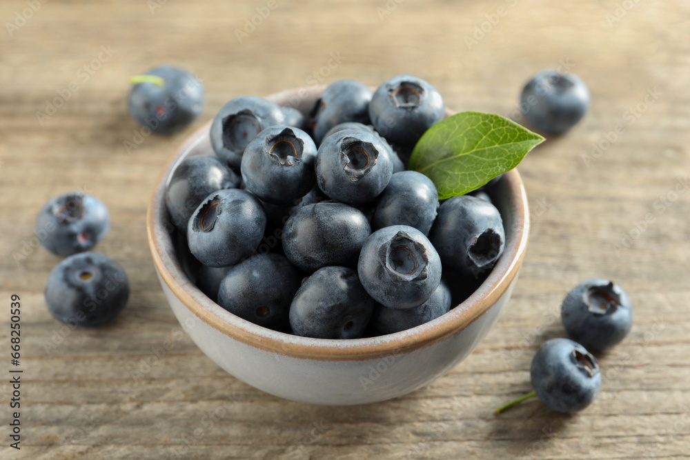 Bowl of tasty fresh blueberries on wooden table, closeup Bowl of tasty fresh blueberries on wooden table, closeup