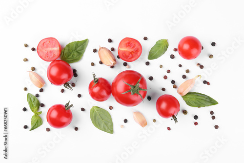 Flat lay composition with different whole and cut tomatoes on white background