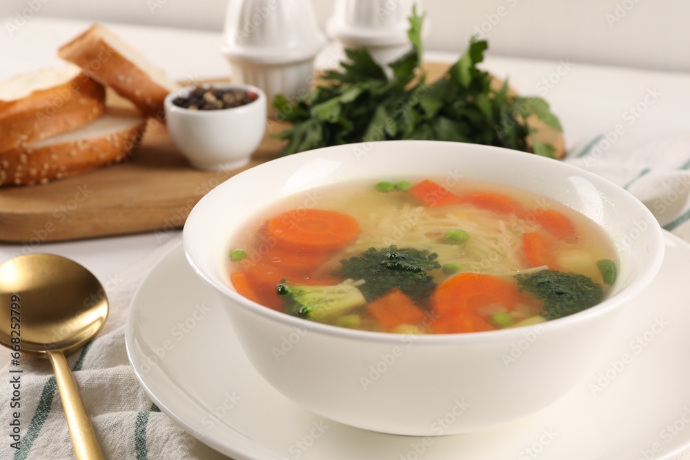 Delicious vegetable soup with noodles and spoon on table, closeup Delicious vegetable soup with noodles and spoon on table, closeup