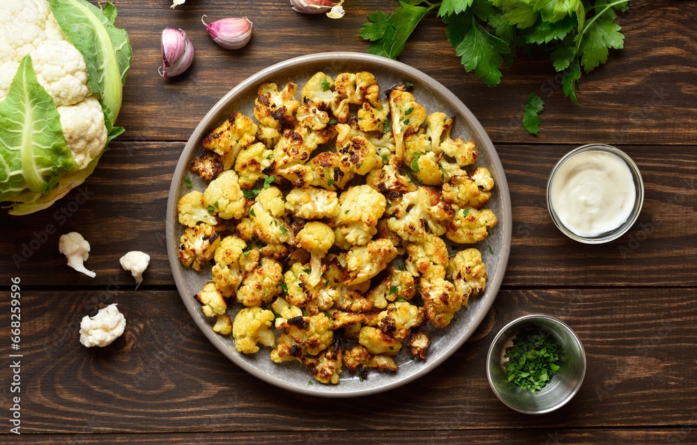 Roasted cauliflower on wooden background Roasted cauliflower on wooden background