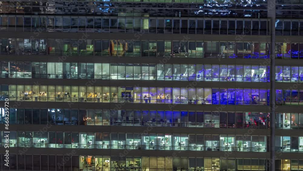 Frontal view of night facade of business tower building with a lot of windows with light timelapse. Life in every window. Aerial view of the glass facade of an office skyscraper. Frontal view of night facade of business tower building with a lot of windows with light timelapse. Life in every window. Aerial view of the glass facade of an office skyscraper.