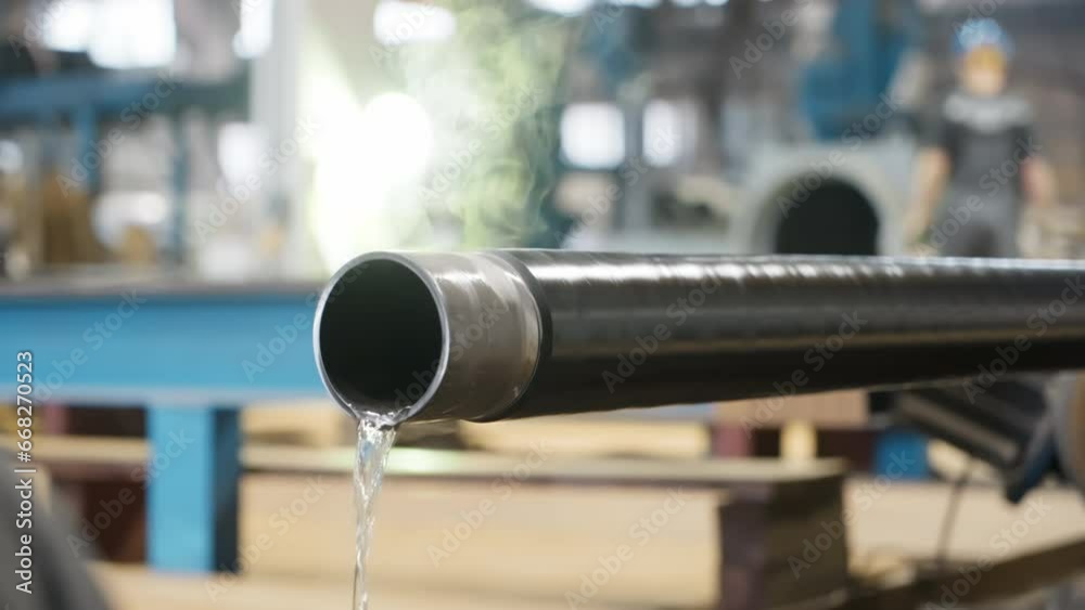 Vapour fumes coming from the hot steel pipe on the factory production line. Vapour disappears from the hot pipe full of water residue. Vapour flying off the manufactured hot pipe. Industrial plant Vapour fumes coming from the hot steel pipe on the factory production line. Vapour disappears from the hot pipe full of water residue. Vapour flying off the manufactured hot pipe. Industrial plant
