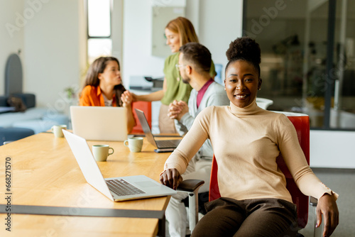 Cute Africam American woman with her young multiethnic startup team working in the modern office © BGStock72
