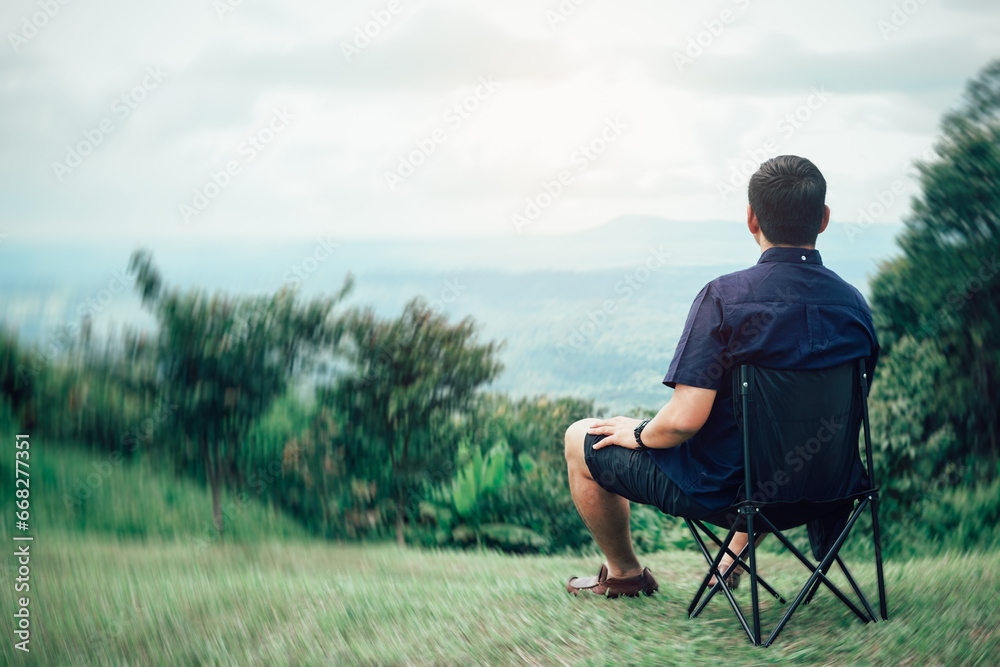 Traveling man relaxing after hiking Sit on a chair and admire the mountain views and natural beauty Traveling man relaxing after hiking Sit on a chair and admire the mountain views and natural beauty